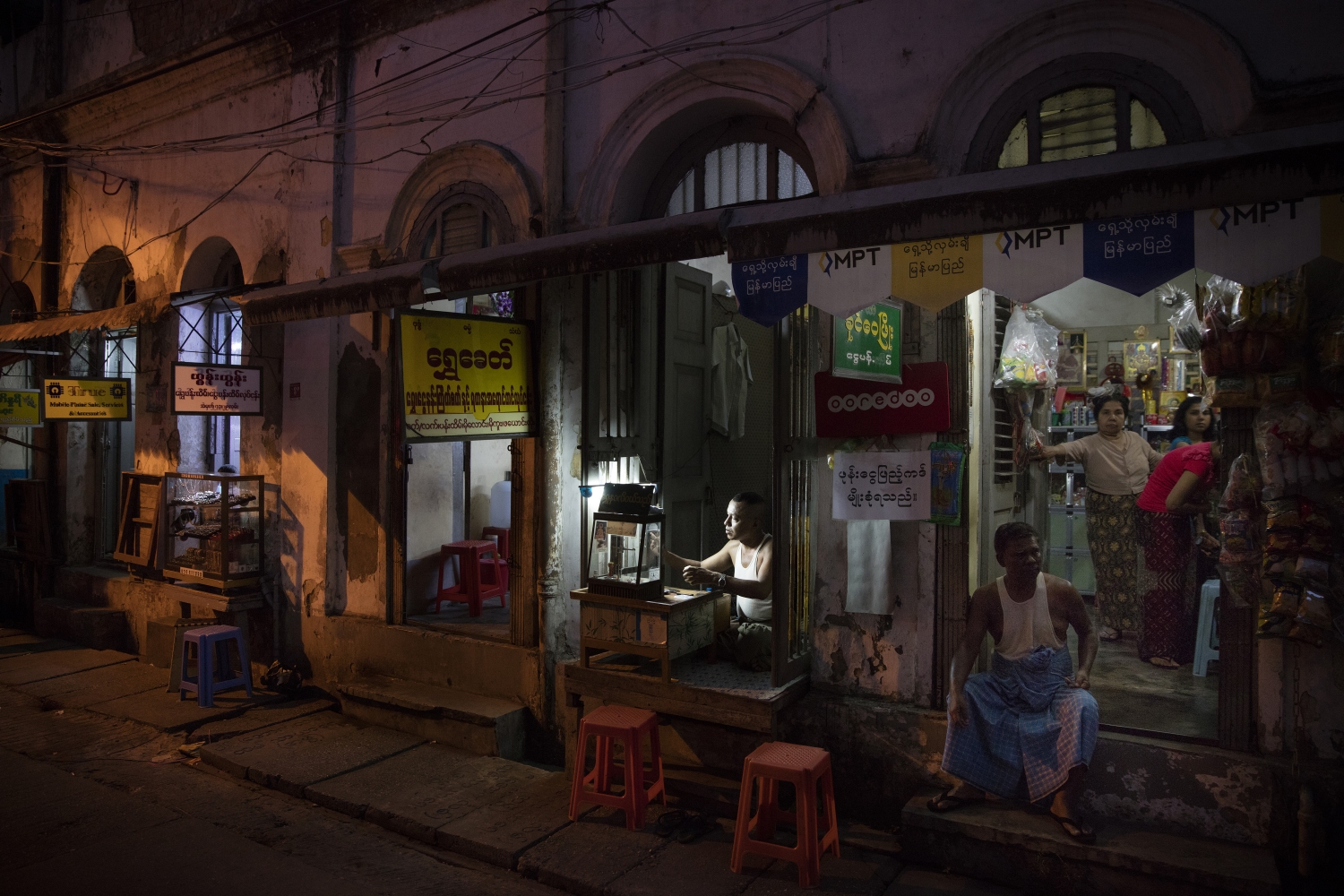 A jewellery merchant at work at dusk in the Indian Quarter of Yangon, Myanmar. Photograph by David Levene