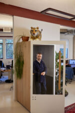 Thomas Heatherwick. British designer and founder of Heatherwick Studio, known for innovative architecture and design projects that combine engineering, sculpture, and urban space. Photographed at his studios in King's Cross, inside a wooden cabin, wearing a blue outfit. London. Photograph by David Levene 24 October 2023