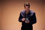 Actor Zachary Quinto poses while holding a Rolleiflex camera against a beige backdrop while in rehearsals for the upcoming production of Best of Enemies, in which he will appear alongside David Harewood at The Young Vic Theatre. London. Photograph by David Levene 26 October 2022