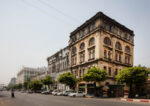 Pansodan Street. Yangon. Myanmar. Historic colonial-era building along a tree-lined street in Yangon, Myanmar, featuring ornate arched windows and weathered cream facades typical of British-era architecture. Photograph by David Levene 23 March 2016