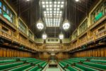 The Commons Chamber. House of Commons. Houses of Parliament. Palace of Westminster. Interior of the House of Commons chamber, UK Parliament, showing rows of empty green leather benches facing each other, ornate carved oak panelling, and large pendant lanterns hanging from a vaulted ceiling, Westminster. London. Photograph by David Levene 6 November 2017