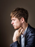 James Blake, British singer-songwriter and producer known for his atmospheric electronic and soul-influenced music, in a profile portrait against a dark studio background, London. Photograph by David Levene, 2 May 2016